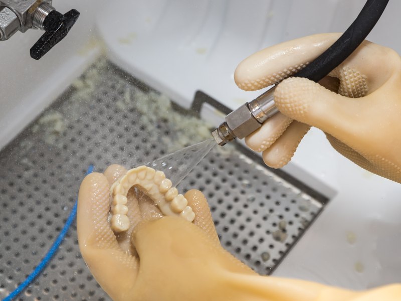 Técnico dental acabando una prótesis completa de arcada en el laboratorio