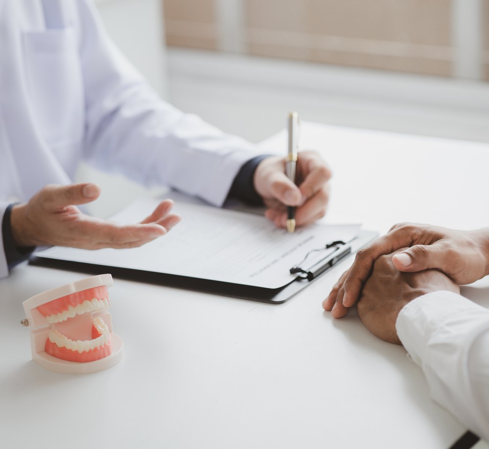 El dentista prepara el presupuesto con el paciente en la consulta