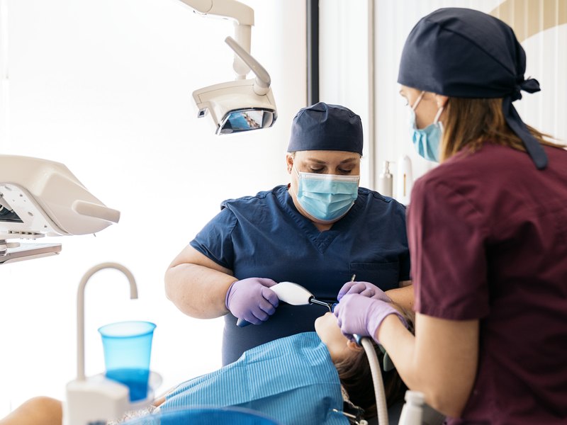 Equipo de cirugía oral atendiendo a un paciente en el quirófano de la clínica