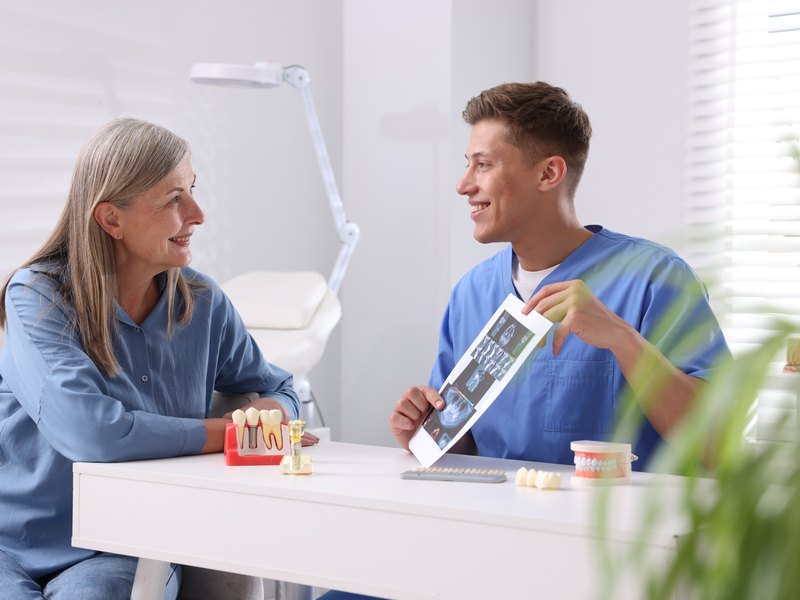 Dentista explicando a una paciente su radiografía panorámica