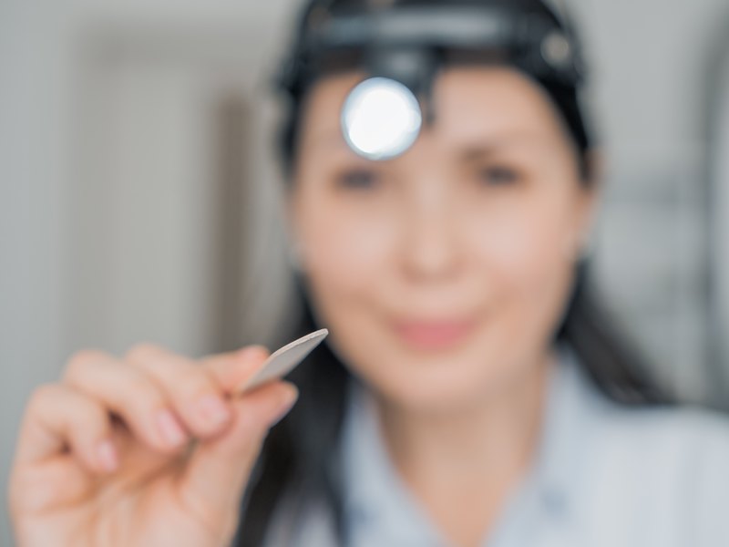 Dentista ensenyant una de les carilles al pacient per triar-ne el to