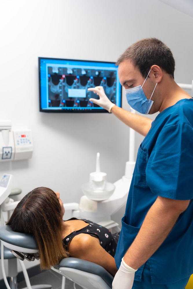 Dentist showing a patient the dental implant plan on the screen