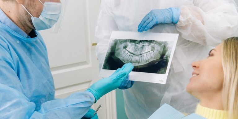 Cirurgià explicant a una pacient la seva radiografia panoràmica abans de la intervenció