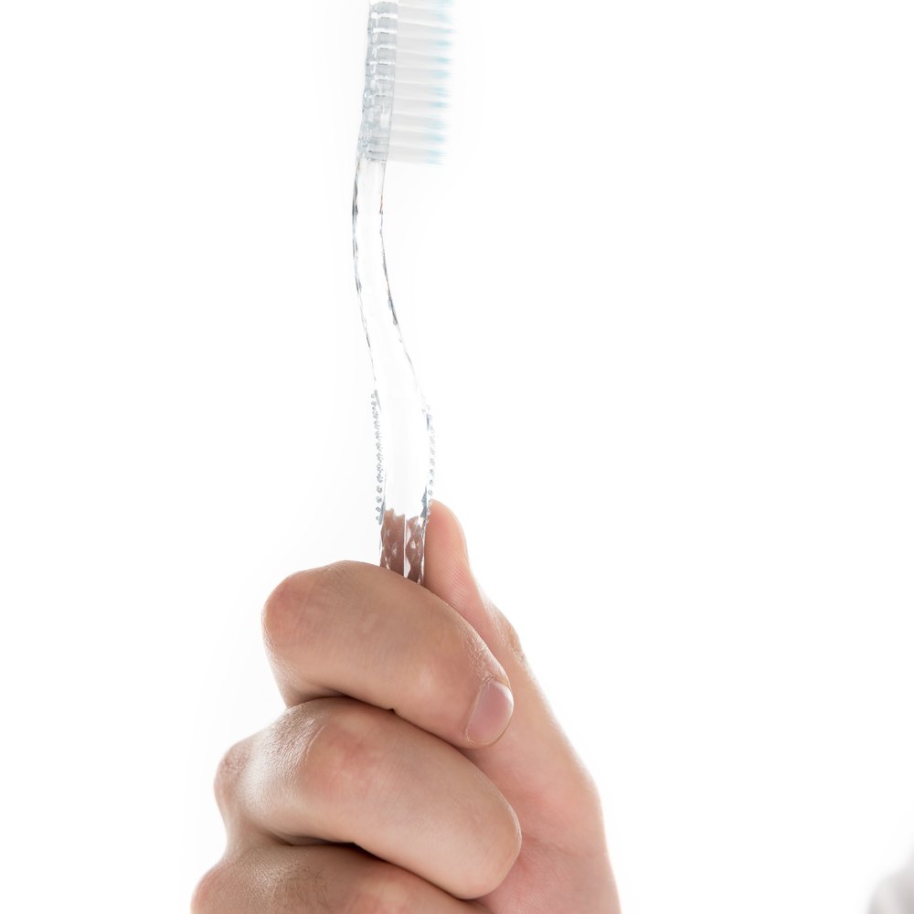 Mà que sosté un raspall de dents de filaments suaus