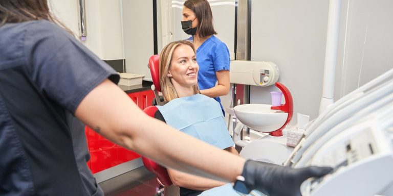 Pacient tranquil·la i somrient a la cadira del gabinet dental abans del tractament
