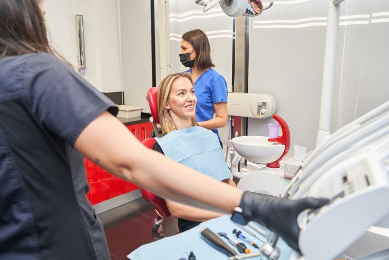 Paciente tranquila y sonriente en el sillón del gabinete dental antes del tratamiento