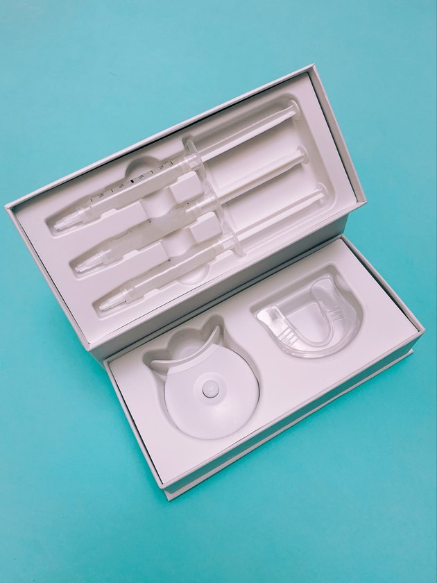 At-home teeth whitening kit with tray, gel syringes and LED light